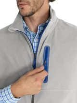 Chaleco polar gris sin mangas, confeccionado en micropolar de poliéster reciclado, con cierre frontal y tres bolsillos con cierre en color azul.