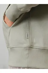 Hoodie tipo canguro color gris mineral, de manga larga con capucha y fit regular. Cuenta con un bolsillo y estampado de goma con tacto suave. Tejido Loop Back.