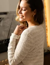 Cardigan de tejido tweed color blanco, marca Catherine Malandrino. Tiene cuello a la base, abertura central con botones perlados, bolsillos simulados en la delantera y bordados en lurex y lentejuelas.