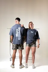 Remera gris con estampado en el frente con la frase "Fear Less". En la espalda tiene un estampado vertical con la frase "More Strength".