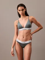 Conjunto de ropa interior Calvin Klein, modelo Modern Cotton, color gris, compuesto por un corpiño triangular con breteles finos regulables y una bombacha tipo tanga. Ambos con banda elástica blanca con logo de la marca.