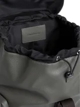 Mochila Calvin Klein de poliuretano en color gris con textura granulada. Presenta un diseño funcional con solapa superior y cierre mediante una correa de tela marrón con el nombre de la marca. Incluye bolsillos laterales tipo cargo con solapa, asa superior y el logo 'ck' grabado en relieve en la esquina inferior frontal.
