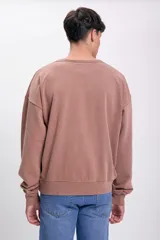 Buzo deportivo color visón, de corte holgado y cuello redondo.
