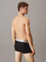 Pack de tres bóxers negros Calvin Klein con cintura elástica plateada y logo de la marca.