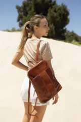 Mochila de cuero marrón, con diseño elegante y detalles en relieve.