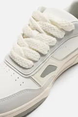 Zapatillas urbanas de estilo skate, color blanco con detalles en gris.