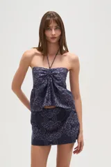 Top sin mangas azul con estampado floral, cuello halter y detalle de punto smock.