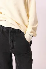 Pantalón de jean negro de corte ancho, con bolsillos laterales y traseros.