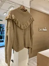 Sweater color beige de tejido de punto con ochos y cuello alto con volados. 