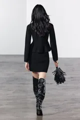 Minifalda negra de punto liso, de tiro alto y cintura elástica.
