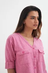 Camisa color crema de algodón con escote en V, mangas 3/4 con trabilla y dos bolsillos con solapa en el pecho.