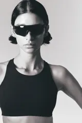 Top deportivo negro de tejido funcional con tecnología ShapeMove™ y DryMove™. Ofrece ajuste ceñido y soporte óptimo. Copas forradas con relleno extraíble, breteles anchos ajustables, espalda nadadora en malla con sección cut-out y cierre de corchetes atrás.