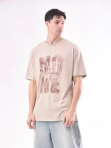 Remera color beige con estampa marrón con texto.