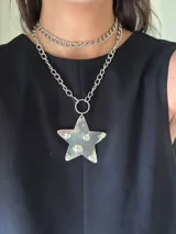 Collar doble con cadena de eslabones plateada, uno corto y otro largo con dije de estrella transparente con estampado de fantasmas.