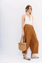 Pantalón babucha color marrón de lino, con cintura elastizada, bolsillos laterales y largo al tobillo.