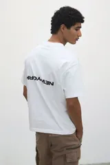Remera blanca de corte holgado con cuello redondo y estampado pequeño con la frase "New York" en el pecho.