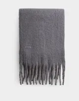 Bufanda rectangular de tejido jacquard en dos tonos de gris, con flecos trenzados en los extremos.