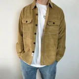 Sobrecamisa color marrón claro de pana con cuello clásico, cierre frontal con botones, dos bolsillos de parche con solapa abotonada en el pecho y mangas largas con puños abotonados.