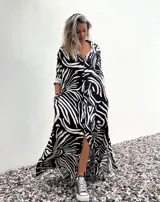 Vestido camisero largo con estampado abstracto en blanco y negro, cierre frontal con botones, mangas 3/4 y cuello camisero.
