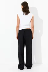 Pantalón negro de corte holgado en algodón, con tiro alto, cintura elástica fruncida y cordón para ajustar. Piernas anchas con bolsillos laterales.