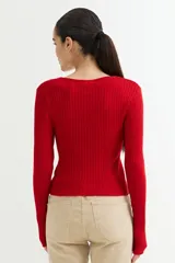 Sweater rojo de tejido de punto acanalado, con escote en V y cierre frontal con cremallera.
