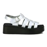 Sandalias blancas con plataforma negra, tiras anchas cruzadas y pulsera con hebilla.