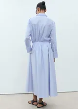 Falda larga color celeste claro, de tejido de algodón, con cintura elástica ajustable mediante cordón y bolsillos laterales.