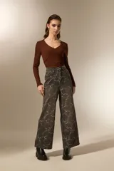 Pantalón de jean azul claro con estampado abstracto desgastado, corte baggy y tiro medio.