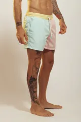 Short de baño para hombre, tiro medio, con estampado tropical en tonos rosados, verdes y blancos. Posee cintura elástica con cordón de ajuste trenzado y bolsillos laterales.