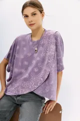 Remera lila con estampado de cachemir, de mangas cortas y cuello redondo. Tiene calce amplio y corte cruzado al frente.