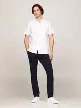 Camisa blanca de algodón Oxford, de corte regular, con cuello abotonado, manga corta y logo de Tommy Hilfiger bordado en el pecho.