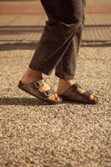 Sandalias de cuero con estampado animal print, dos hebillas ajustables y plantilla de cuero.