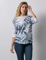Buzo blanco con estampado de hojas en tonos azulados, de cuello redondo y mangas 3/4.