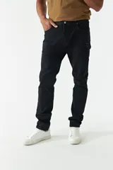 Jean azul oscuro de corte recto, con tiro medio, roturas en la pierna y logo bordado en el bolsillo trasero.