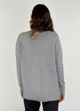 Sweater negro con detalles brillantes en la parte frontal, de manga larga y corte clásico.