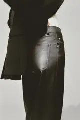 Pantalón de cuero sintético negro, de corte recto, tiro alto y cinco bolsillos.