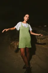 Vestido corto dorado de tejido de punto con breteles finos y escote en V.