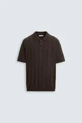 Polo marrón de punto canalé con cuello solapa, cierre frontal de botonadura, manga corta y corte regular fit.