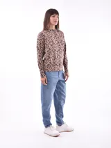 Sweater color beige con estampado de leopardo, cuello redondo y mangas largas.