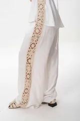 Pantalón sastrero de lino italiano color negro con guarda de broderie crudo desde la cintura hasta el bajo.