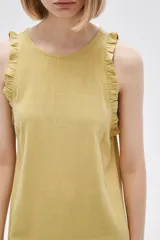 Vestido corto color crema, sin mangas, con cuello redondo y volados en los hombros.