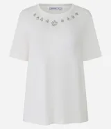 Remera blanca de viscosa con cuello redondo, mangas cortas y apliques de strass en el cuello.