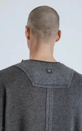 Sweater gris oscuro de manga larga con cuello redondo y paneles laterales con costuras a la vista.