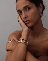 Brazalete dorado con diseño de círculos irregulares.