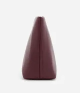 Neceser de poliuretano color borgoña, con forma trapezoidal y cierre de cremallera.