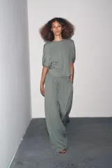 Pantalón de tiro medio con cintura elástica ajustable con cordones, de pierna ancha y bolsillos laterales ocultos en costura. Confeccionado en hilatura con mezcla de lyocell.