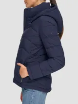 Campera acolchada azul marino de poliéster con cuello con capucha, cierre de cremallera, bolsillos frontales con cremallera y logo Calvin Klein.