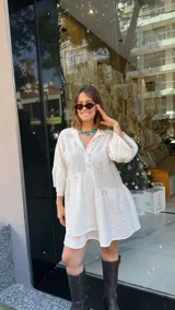 Vestido corto blanco con bordado calado, corte holgado, cuello camisero y mangas 3/4 con volados.