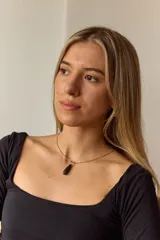 Collar dorado con cadena fina y dije colgante en forma de lágrima de piedra natural azul con vetas blancas.