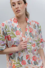 Conjunto de pijama de algodón a rayas verticales rosas y blancas, con detalles en celeste. Incluye camisa de manga corta con botones y bolsillo en el pecho, y shorts con cintura elástica.